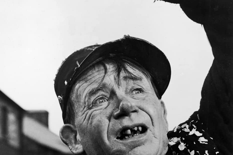 Actor John Mills as the character Michael in Ryan's Daughter; he's wearing. flat cap, torn and ragged clothing, has teeth missing and is described as the (derogatory) "village halfwit"